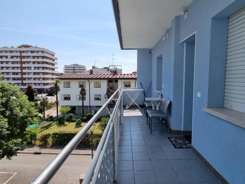 a balcony of a blue building with a table at Appart-Hotel Holiday in Lignano Sabbiadoro