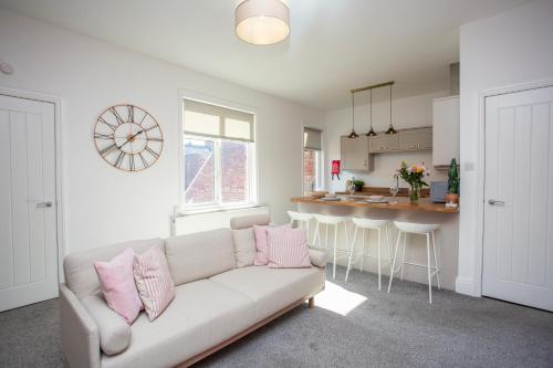 a living room with a couch and a kitchen at Balmoral Gardens - Vacant Nests in North Shields
