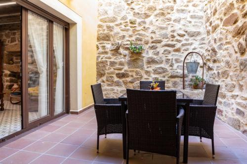 a patio with a table and chairs and a stone wall at Casa Rural El Mesón 9 in Fermoselle