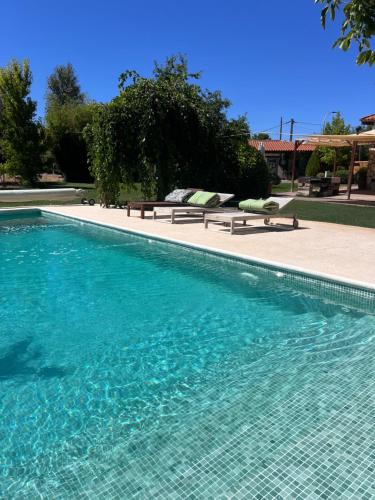 a swimming pool with two benches next to at Espacio Shangrila.One in Uceda