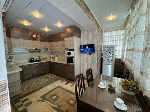 a kitchen with a dining table and a refrigerator at Modern and Cozy Apartment in Baku in Baku
