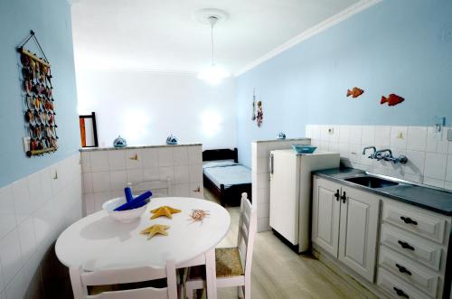 a small kitchen with a white table and a white refrigerator at Golden Apartments in Agios Nikolaos