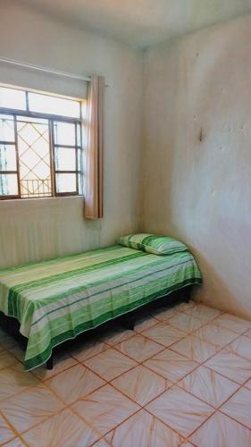 a bed in a corner of a room with a window at Apto com Estac Gratis e Conforto in Paragominas
