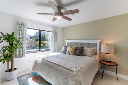 a bedroom with a bed with a ceiling fan and a window at 400 South in Cocoa Beach