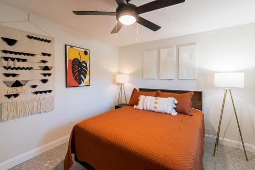 a bedroom with an orange bed and a ceiling fan at 400 South in Cocoa Beach