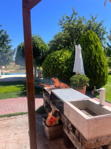 a fire pit with an umbrella in a yard at Espacio Shangrila.One in Uceda