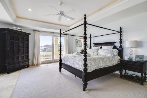 a bedroom with a canopy bed and a window at 31 Singleton Beach- Oceanfront luxury home, spectacular views & private pool, FREE Activities Included in Hilton Head Island