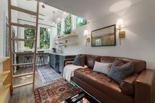 a living room with a brown couch and a kitchen at Extended Stay Retreat Top Notch Deck with Greenbelt View in Austin