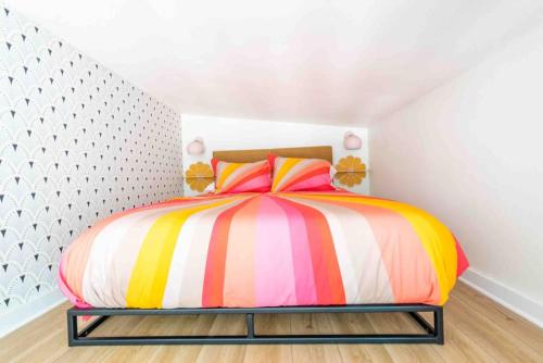 a bedroom with a bed with a colorful striped comforter at Unique Vintage Vibes - Cozy Tiny Home close to UT in Austin