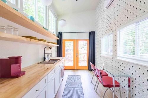 une cuisine avec un comptoir et des chaises rouges dans l'établissement Unique Vintage Vibes - Cozy Tiny Home close to UT, à Austin