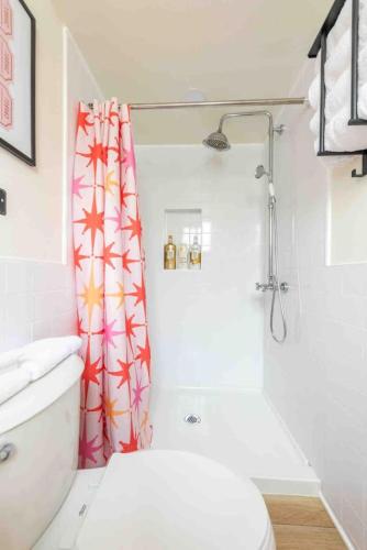a bathroom with a toilet and a shower curtain at Unique Vintage Vibes - Cozy Tiny Home close to UT in Austin