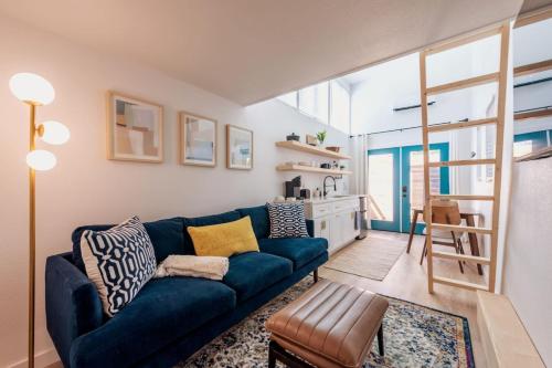a living room with a blue couch and a table at Cozy and Bright Mid-Century Gem in Eastside Action in Austin