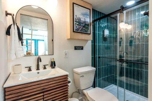 a bathroom with a toilet and a sink and a shower at Cozy and Bright Mid-Century Gem in Eastside Action in Austin