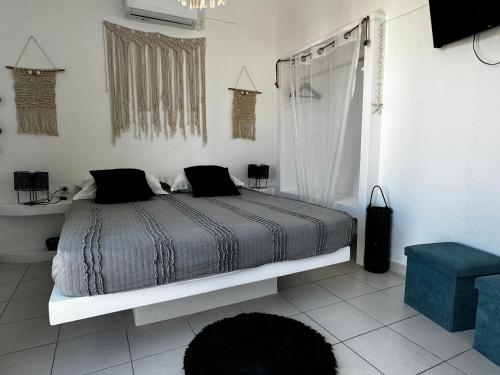 a white bedroom with a bed and a shower at Eris Studios in Adamas