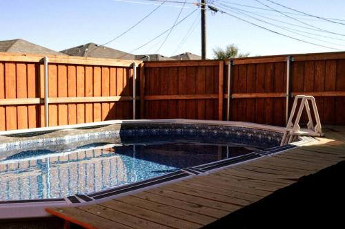 a swimming pool in a backyard with a wooden fence at McKinley House Prime - Pool, Patio and Garage in Amarillo