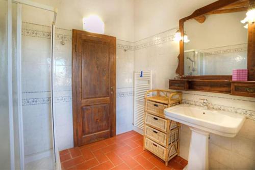 een badkamer met een wastafel, een douche en een spiegel bij Chianti House in Gaiole in Chianti