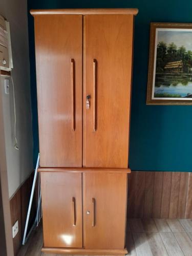 a large wooden cabinet in a room with a wall at Casa em Botafogo (Rio de Janeiro) in Rio de Janeiro