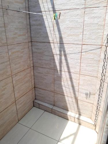 a shower stall with a shower curtain and a shadow at Casa em Botafogo (Rio de Janeiro) in Rio de Janeiro