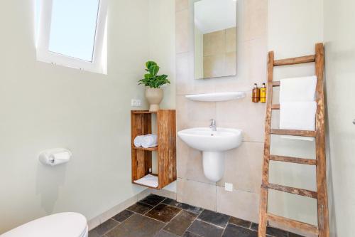 a bathroom with a toilet and a sink at Bayside Boutique Hotel - Blue Bay Golf & Beach Resort in Willemstad
