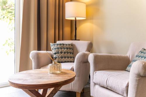 a living room with two chairs and a table at Bayside Boutique Hotel - Blue Bay Golf & Beach Resort in Willemstad