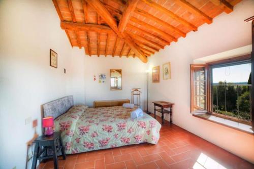 een slaapkamer met een bed en een groot raam bij Chianti House in Gaiole in Chianti