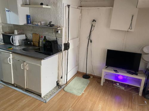 Il comprend une cuisine avec un évier et un bureau avec une télévision. dans l'établissement Ritaj, à Paris