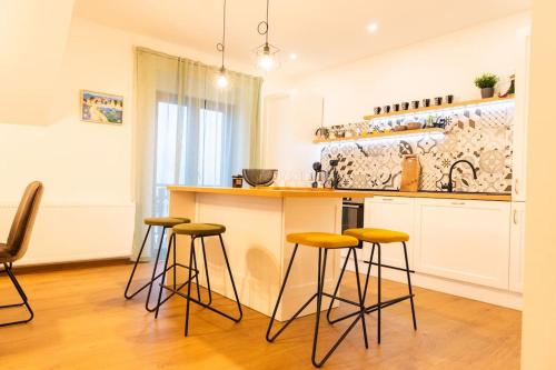 a kitchen with a counter and stools in a room at Atmosfera di montagna a Tarvisio in Tarvisio