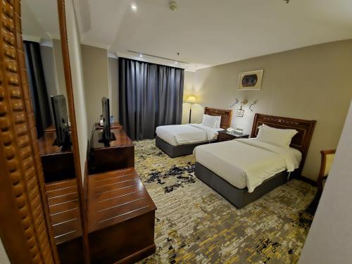a hotel room with two beds and a television at Elite Park Hotel in Jeddah