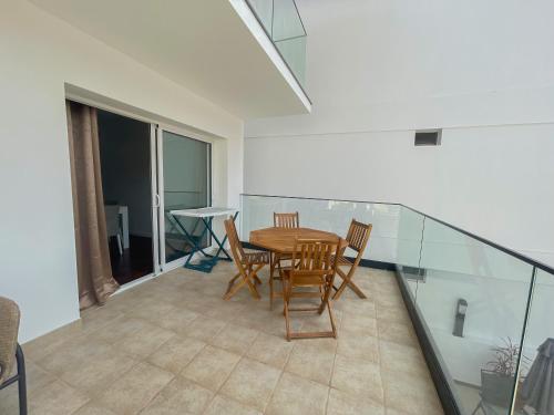 a dining room with a table and chairs on a balcony at Villa Supranee Relaxation in Câmara de Lobos
