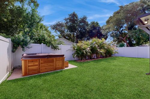 a backyard with a hot tub in the grass at Bayside Bungalow in Tampa