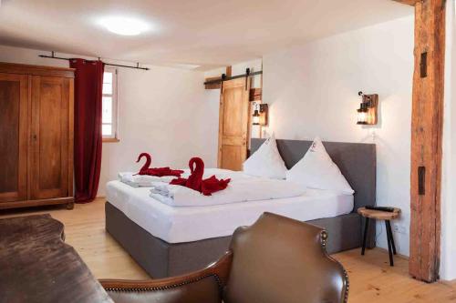 a bedroom with a bed with two red birds on it at Bodensee Hotel Storchen in Uhldingen-Mühlhofen