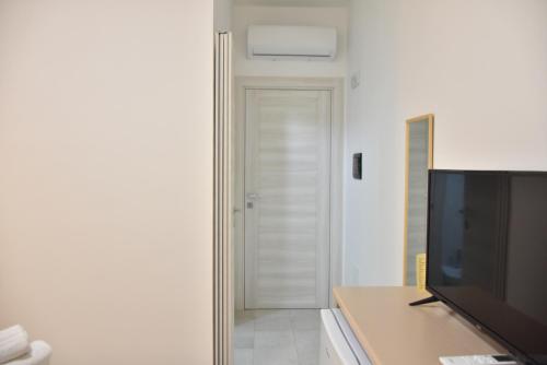 a living room with a flat screen tv next to a door at Hotel Villa del Sole in Porto Cesareo