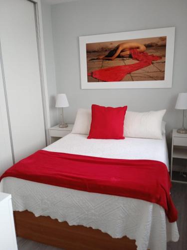 a bedroom with a bed with a red blanket at Casa Ríos in El Burgo