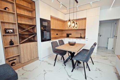 eine Küche mit einem Holztisch und Stühlen in der Unterkunft AGIA- luxury apartment Sofia in Sofia
