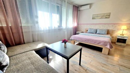 a living room with a couch and a bed and a table at Apartmani Paku in Belgrade
