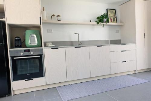 a kitchen with white cabinets and a sink at Between Valley & Mountain in Yoqne‘am