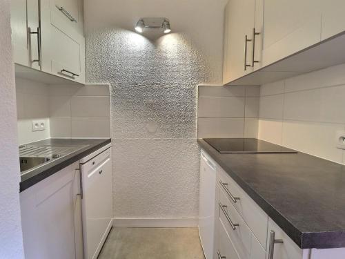 une cuisine blanche avec des armoires blanches et un évier dans l'établissement Duplex 5/6 pers, aux pieds des pistes, proche commerces, balcon, WiFi, animaux OK - FR-1-182-137, à Méribel