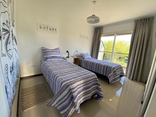 Venetto Village في فيلا باركيه سيكيمان: سريرين مع بطانيات مخططة في الغرفة