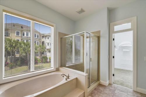 a large bathroom with a tub and a window at 6 Collier Beach Road- Oceanfront, Large Pool, Elevator, FREE Activities Included in Hilton Head Island