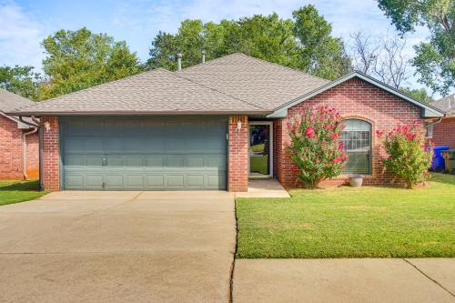 a red brick house with a gray garage at 5 Mi to University of Oklahoma Home with Patio! in Norman