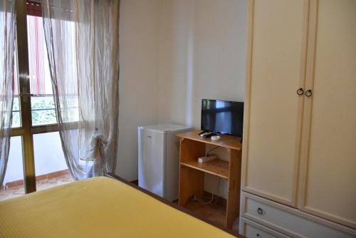 a bedroom with a bed and a television on a table at Hotel Villa del Sole in Porto Cesareo