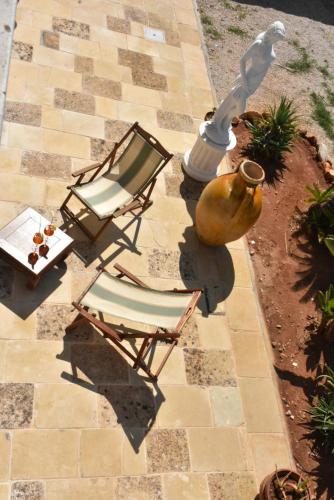 a chair and a table and a vase on a patio at Hotel Villa del Sole in Porto Cesareo