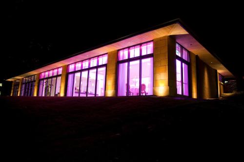 a building with lit up windows at night at The Wood Norton in Evesham