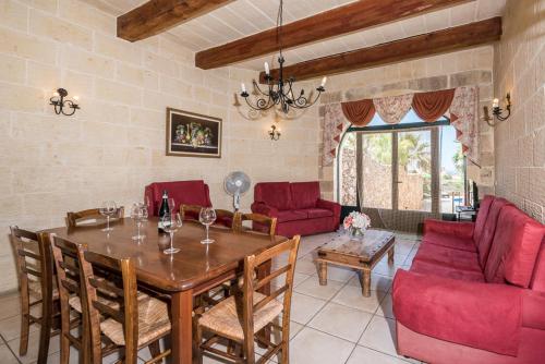 ナダにある4 Bedroom Farmhouse with Private Pool & Viewsのリビングルーム(木製テーブル、赤い椅子付)
