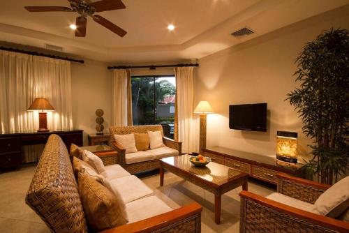 ein Wohnzimmer mit Couch und Fernseher in der Unterkunft Monaco Condominiums in Jacó