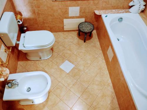 a bathroom with a toilet and a sink and a tub at PerlaVerde in Patti