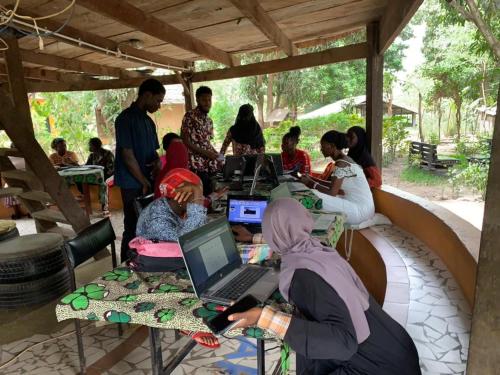 a group of people sitting around a table with laptops at MyFarm - Nema Kunku - An Educational Centre in Ker Dobaly