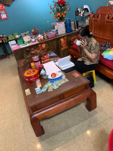 Eine Frau, die auf einer Couch mit einem Tisch sitzt. in der Unterkunft Golden Bell Backpacker Hostel in Ninh Bình