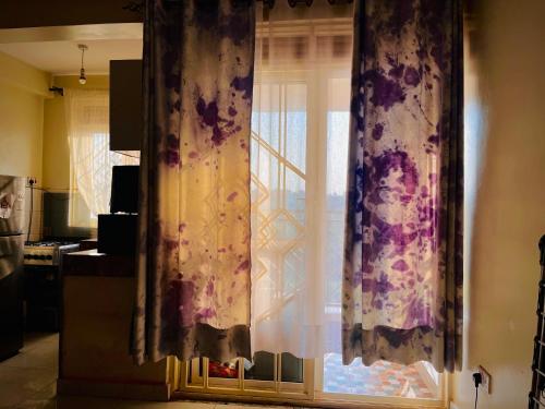a window in a kitchen with curtains on it at Saginias Nest in Kyambogo