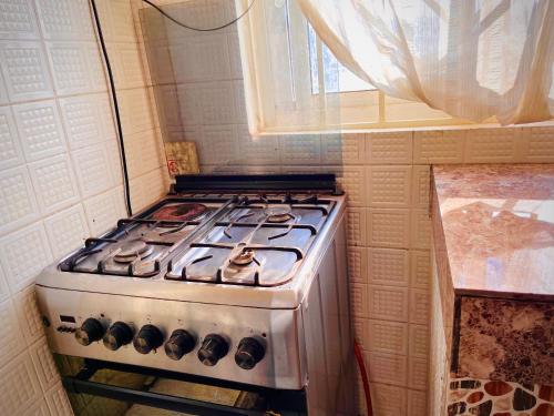 a stove top oven in a kitchen with a window at Saginias Nest in Kyambogo
